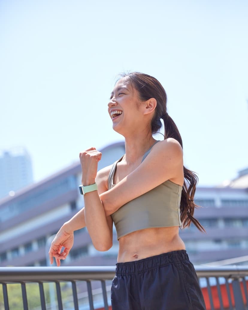 屋外でストレッチする笑顔の女性
