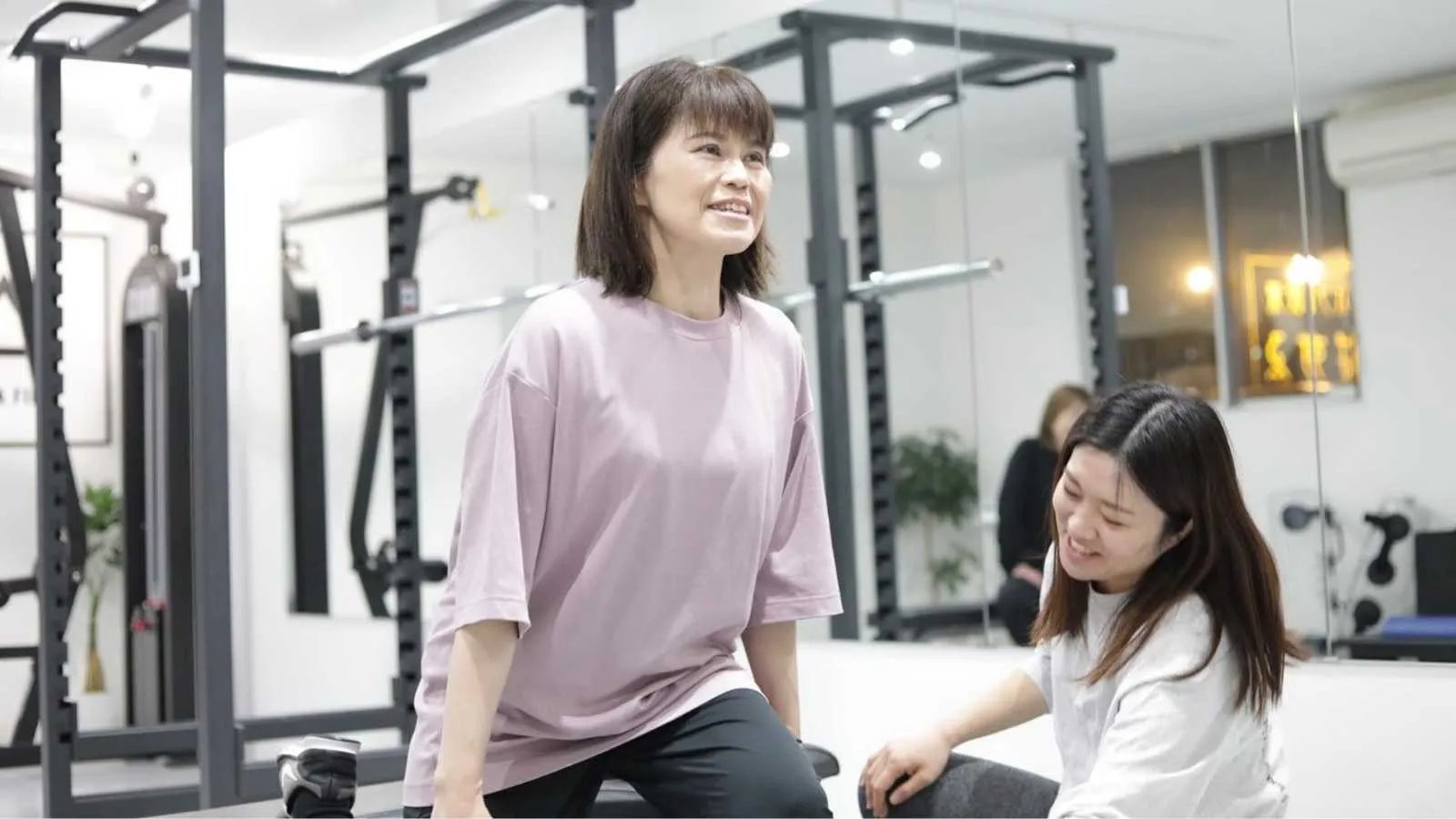 ジムでトレーニング指導を受けている女性